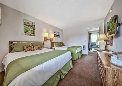 a hotel room with two beds and a desk at Walker River Lodge in Bridgeport
