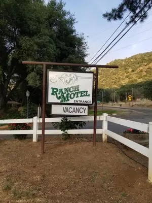 a sign for a motel in front of a fence at Lazy J Ranch Motel in Three Rivers