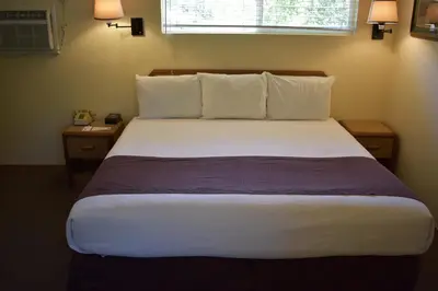 a bedroom with a large bed with white sheets and pillows at Lazy J Ranch Motel in Three Rivers