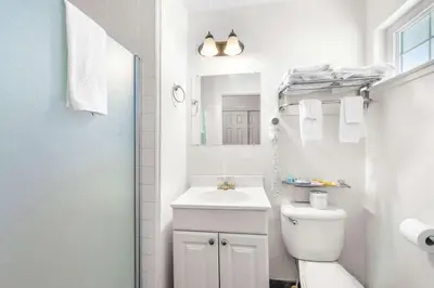 a white bathroom with a sink and a toilet at Quality Inn & Suites Jackson in Jackson
