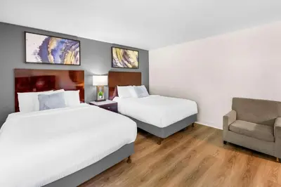 a hotel room with two beds and a chair at Quality Inn & Suites Jackson in Jackson