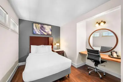 a hotel room with a bed and a desk and a mirror at Quality Inn & Suites Jackson in Jackson