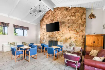 a restaurant with a stone wall with tables and chairs at Quality Inn & Suites Jackson in Jackson