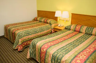a hotel room with two beds and a lamp at King's Rest Motel in Gilroy