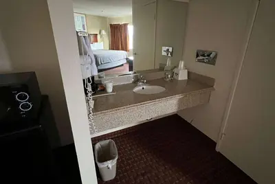a bathroom with a sink in a hotel room at Days Inn & Suites by Wyndham Rancho Cordova in Rancho Cordova