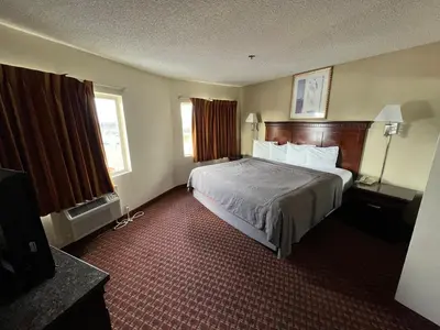 a hotel room with a bed and a television at Days Inn & Suites by Wyndham Rancho Cordova in Rancho Cordova