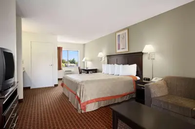 a hotel room with a bed and a couch at Days Inn & Suites by Wyndham Rancho Cordova in Rancho Cordova