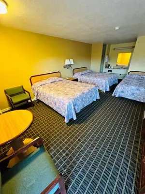 a hotel room with two beds and a table at Mount Whitney Motel in Lone Pine