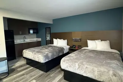 a hotel room with two beds and a kitchen at Baymont by Wyndham Coalinga in Coalinga