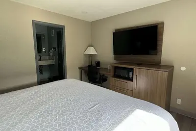 a hotel room with a bed and a flat screen tv at Baymont by Wyndham Coalinga in Coalinga