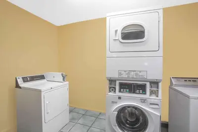 a laundry room with a washing machine and a washer at Baymont by Wyndham Coalinga in Coalinga