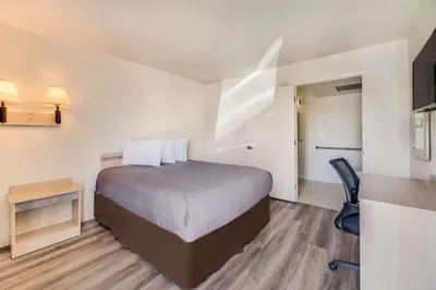 a small hotel room with a bed and a chair at Econo Lodge Stockton near I-5 Fairgrounds in Stockton