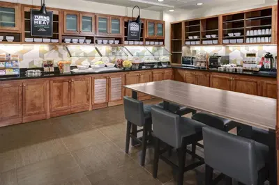 a kitchen with a long wooden table and chairs at Hyatt Place Sacramento Rancho Cordova in Rancho Cordova