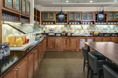 a large kitchen with wooden cabinets and a counter top at Hyatt Place Sacramento Rancho Cordova in Rancho Cordova