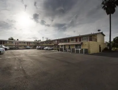 an empty parking lot in front of a hotel at Sky Riders Motel in Sacramento