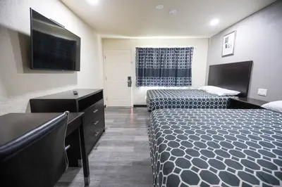 a hotel room with two beds and a flat screen tv at Sky Riders Motel in Sacramento