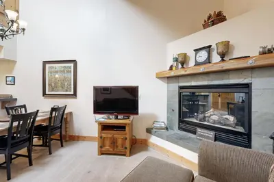 a living room with a fireplace and a television at Tavern Inn #55 in Olympic Valley