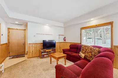 a living room with a red couch and a tv at Inviting, Comfortable Mountain Home in Truckee