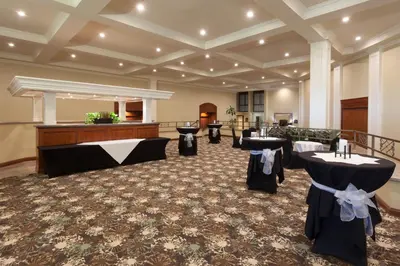 a banquet hall with tables and a podium in a room at Wyndham Visalia in Visalia