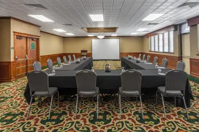 a conference room with a table and chairs and a whiteboard at Wyndham Visalia in Visalia