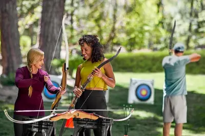 a woman holding a bow and arrows in front of a target at Hyatt Regency Lake Tahoe Resort, Spa & Casino in Incline Village