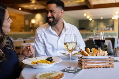 a man and woman sitting at a table with food and wine at Hyatt Regency Lake Tahoe Resort, Spa & Casino in Incline Village
