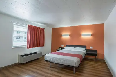 a bedroom with a bed with an orange wall at Motel 6-Fallon, NV in Fallon