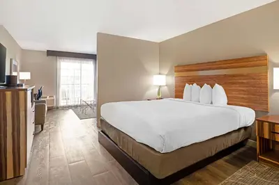a hotel room with a large bed and a desk at Best Western Cedar Inn & Suites in Angels Camp