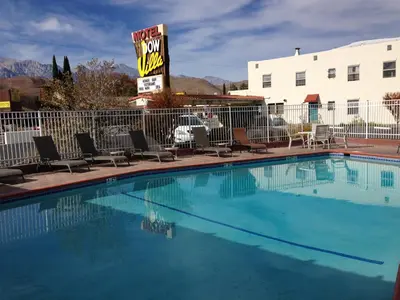 a large swimming pool with chairs and a hotel sign at Dow Villa Motel in Lone Pine
