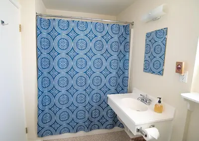 a bathroom with a blue shower curtain and a sink at Mt Williamson Motel and Basecamp in Independence