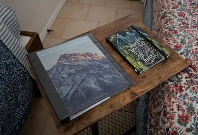two books on a table next to a bed at Mt Williamson Motel and Basecamp in Independence