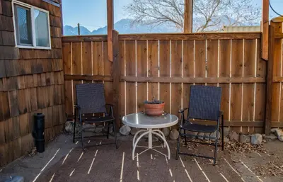 two chairs and a table in front of a fence at Mt Williamson Motel and Basecamp in Independence
