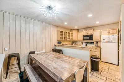 a kitchen with a wooden table and a refrigerator at Courchevel 57 in Mammoth Lakes