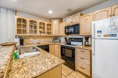 a kitchen with wooden cabinets and a white refrigerator at Courchevel 57 in Mammoth Lakes