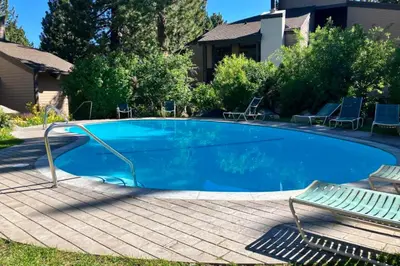 a large blue swimming pool with chairs next to a house at Sherwin Villas 39 in Mammoth Lakes