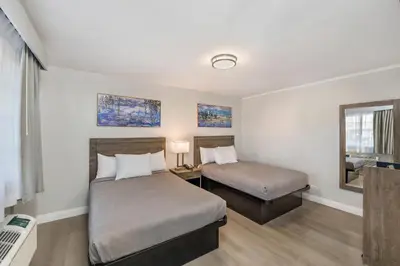 a hotel room with two beds and a mirror at Rodeway Inn Stockton Highway 99 in Stockton