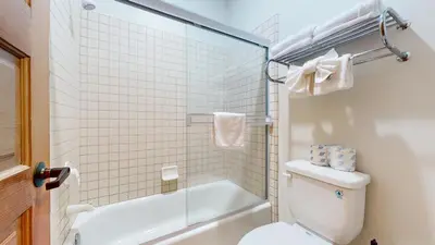 a white bathroom with a toilet and a shower at Snowcreek V #997 Condo in Mammoth Lakes