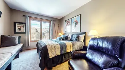 a bedroom with a bed and a couch and a window at Snowcreek V #997 Condo in Mammoth Lakes