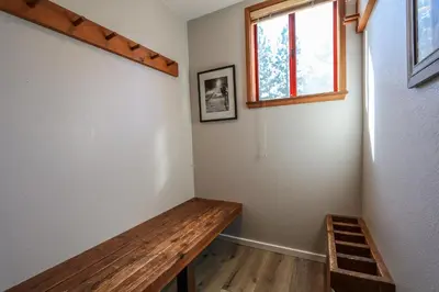 a room with a wooden bench and a window at Aspen Creek #306 Condo in Mammoth Lakes