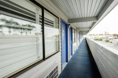 a corridor of a building with windows and a sidewalk at Budget Inn Corcoran Near Tulare CA 43 in Corcoran