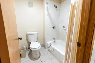 a bathroom with a toilet and a tub and a sink at Budget Inn Corcoran Near Tulare CA 43 in Corcoran