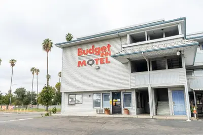 a building with a burgerventh month sign on it at Budget Inn Corcoran Near Tulare CA 43 in Corcoran
