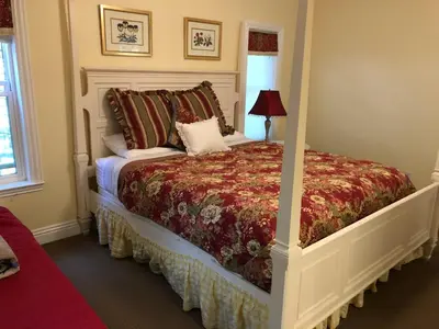 a bedroom with a bed with a red comforter at Carriage House at Yosemite in Fish Camp
