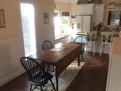a kitchen and dining room with a wooden table and chairs at Carriage House at Yosemite in Fish Camp