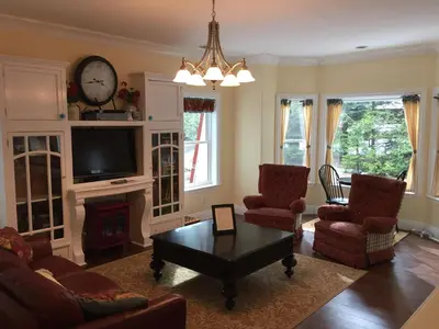 a living room with a table and chairs and a tv at Carriage House at Yosemite in Fish Camp