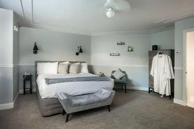 a bedroom with a large bed and a chair at Hounds Tooth Inn in Oakhurst