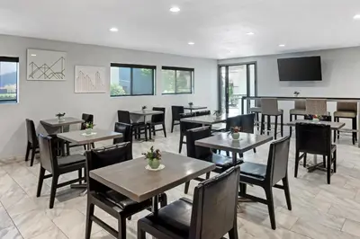 a restaurant with tables and chairs and a flat screen tv at Best Western Big Country Inn in Coalinga