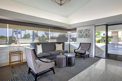 a living room with a couch and two chairs at Best Western Big Country Inn in Coalinga