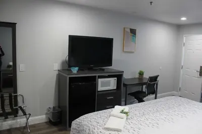 a bedroom with a bed and a flat screen tv at SureStay Hotel by Best Western Chowchilla Yosemite in Chowchilla