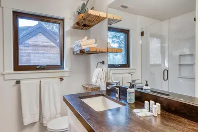 a bathroom with a sink and a toilet and a window at Lake Front Family Home at Donner in Truckee
